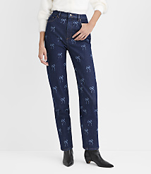 A person wears a white fuzzy sweater, dark blue jeans with light blue bow patterns, and black pointed-toe boots against a plain white background. carousel Product Image 1