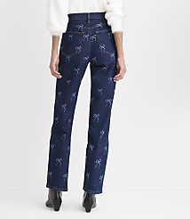 A person wearing a white fuzzy sweater and dark blue jeans with light blue bow patterns stands against a plain white background. carousel Product Image 3