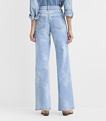 A person wearing a denim shirt and light-wash floral print wide-leg jeans stands against a plain white background. carousel Product Image 2