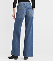A person wearing a black top, wide-leg blue jeans, and black boots stands against a plain white background. carousel Product Image 2