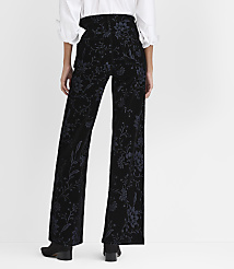 A person stands with their back to the camera wearing a white blouse and floral-patterned black velvet trousers against a plain white background. carousel Product Image 2