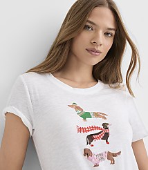 A woman wearing a white t-shirt with three dachshunds in holiday outfits stands against a plain white background. carousel Product Image 1