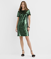 A woman wearing a short-sleeved green sequin dress and black fuzzy heels stands against a plain white background. carousel Product Image 1
