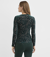 A woman wearing a green floral velvet top and matching pants stands against a plain white background. carousel Product Image 3