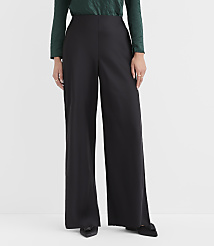 A person wearing a green top and wide-leg black trousers stands against a plain white background. carousel Product Image 2