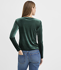 A woman wearing a dark green velvet long-sleeved top and blue jeans stands with her back to the camera against a plain light gray background. carousel Product Image 3