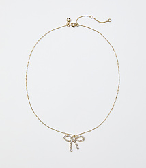 A gold chain necklace with a diamond-encrusted bow pendant rests against a plain white background. carousel Product Image 1