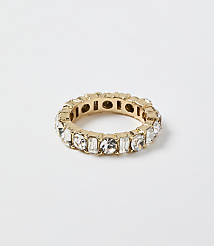 A gold ring set with clear crystals rests on a plain white background. carousel Product Image 1