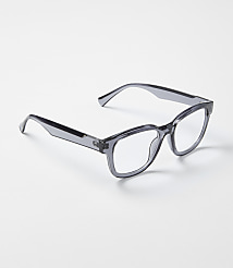 A pair of translucent grey glasses rests on a plain, light-colored surface. carousel Product Image 1