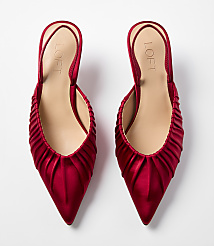 A pair of red satin pointed-toe mules with ruched detailing sits against a plain white background. carousel Product Image 3