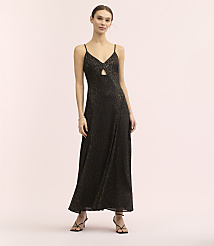 A woman wearing a long, leopard-print black dress and strappy heels stands against a plain, light-colored background. carousel Product Image 2