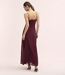 A woman in a long, floral burgundy dress and black heels stands against a plain, light pink background. carousel Product Image 3