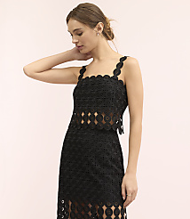 A woman wearing a black lace two-piece outfit stands against a plain light pink background. carousel Product Image 1