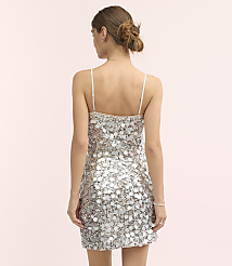 A woman with her hair in a bun wears a silver sequined mini dress against a plain light pink background. carousel Product Image 3
