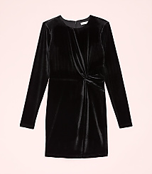 A long-sleeved black velvet dress with a twisted waist detail is centered against a pale pink background. carousel Product Image 4