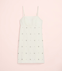 A white mini dress with silver embellishments is centered against a solid light pink background. carousel Product Image 2