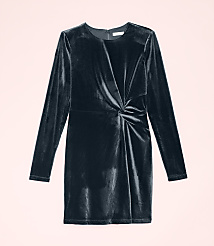 A dark navy velvet long-sleeved dress with a twisted waist detail is centered against a pale pink background. carousel Product Image 2
