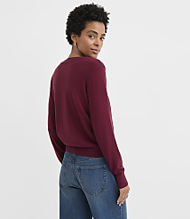A woman wearing a burgundy sweater and blue jeans poses against a plain white background. carousel Product Image 3
