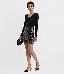 A woman wearing a black velvet top and a sequined mini skirt stands against a plain white background. carousel Product Image 1