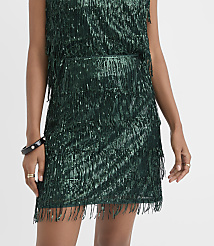 A person wears a shimmering dark green sequined fringe dress against a plain white background. carousel Product Image 2