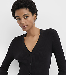 A woman with short curly hair wearing a black ribbed cardigan poses against a plain white background. carousel Product Image 4