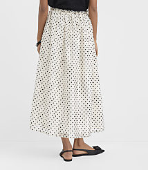 A person wearing a black top and a white polka-dot maxi skirt with black flats stands against a plain white background. carousel Product Image 3