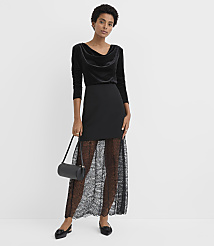 A woman wearing a black velvet top and a black lace skirt stands against a plain white background. carousel Product Image 1