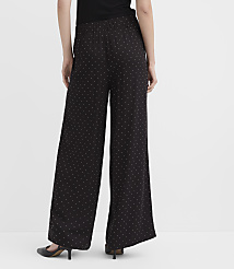 A person wearing black polka-dot wide-leg trousers and black heels stands against a plain white background. carousel Product Image 4