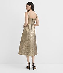 A woman wearing a shimmering gold midi dress and black heels stands with her back to the camera against a plain white background. carousel Product Image 3