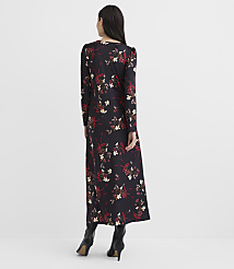 A woman stands with her back to the camera wearing a long-sleeved floral maxi dress and black high-heeled boots against a plain white background. carousel Product Image 3