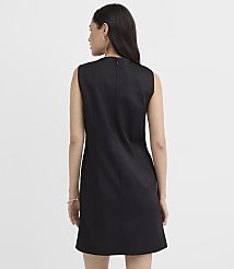A woman wearing a sleeveless black dress stands with her back to the camera against a plain white background. carousel Product Image 3
