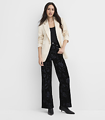 A woman wearing a cream blazer and floral black trousers stands against a plain white background. carousel Product Image 2