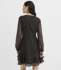 A woman stands with her back to the camera wearing a black floral mini dress against a plain white background. carousel Product Image 3