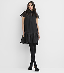 A woman wearing a black dress, tights, and fuzzy heels stands against a plain white background. carousel Product Image 3