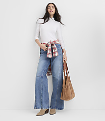 A woman wearing a white top, wide-leg jeans, and a red plaid shirt tied around her waist stands against a plain white background. carousel Product Image 2