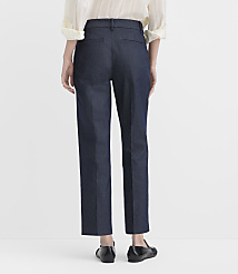 A person stands with their back to the camera wearing a cream blouse, dark blue trousers, and black flats against a plain white background. carousel Product Image 3