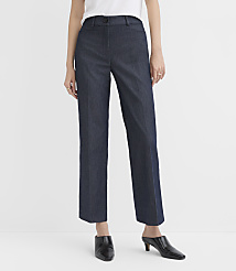 A person wearing a white top, dark blue trousers, and black pointed-toe mules stands against a plain white background. carousel Product Image 1