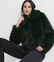 A woman wearing a dark green faux fur jacket and black jeans poses against a plain white background. carousel Product Image 1