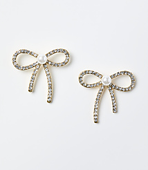 Two gold-toned bow earrings adorned with crystals and a central pearl rest on a plain white background. carousel Product Image 1