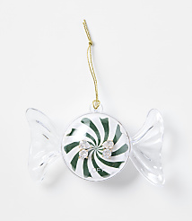 A pair of sparkling stud earrings sits inside a candy-shaped clear plastic ornament with a green and white swirl background, set against a plain white surface. carousel Product Image 1