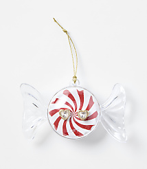 A clear candy-shaped ornament with a red and white peppermint center and two heart-shaped gems sits against a plain white background. carousel Product Image 1