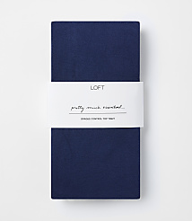 A folded pair of navy blue opaque control top tights with a white band in the middle featuring the "LOFT" logo and text, against a plain white background. carousel Product Image 1
