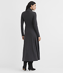 A woman wearing a long-sleeved, charcoal grey maxi dress and black boots stands against a plain white background. carousel Product Image 3