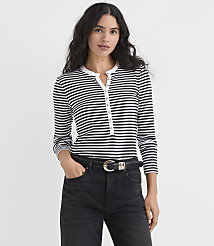 A woman wearing a black and white striped long-sleeve shirt and black jeans stands against a plain white background. carousel Product Image 1