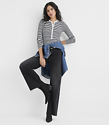 A woman wearing a striped shirt and wide-leg black pants with a denim shirt tied around her waist stands against a plain white background. carousel Product Image 2