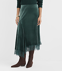 A person wearing a dark green velvet skirt with lace trim and brown boots stands against a plain white background. carousel Product Image 2