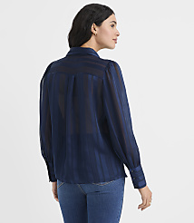 A woman wearing a navy blue striped blouse and blue jeans stands against a plain white background. carousel Product Image 3