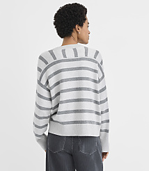 A woman wearing a grey and white striped sweater and dark grey pants stands against a plain white background. carousel Product Image 3
