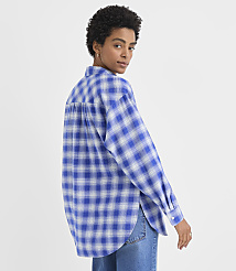 A woman wearing a blue and white plaid shirt and jeans poses against a plain white background. carousel Product Image 3