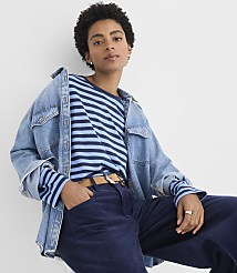 A person wearing a blue striped shirt, a denim jacket, and navy corduroy pants poses against a plain white background. carousel Product Image 1